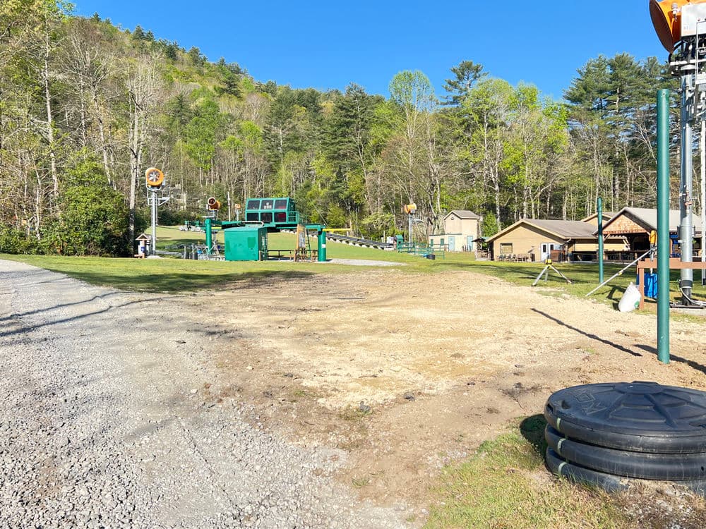 Outdoor recreation area with playground, picnic shelters, and scenic tree-covered hills.